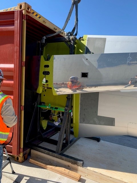 Equipment loading into shipping container — heavy lift operation